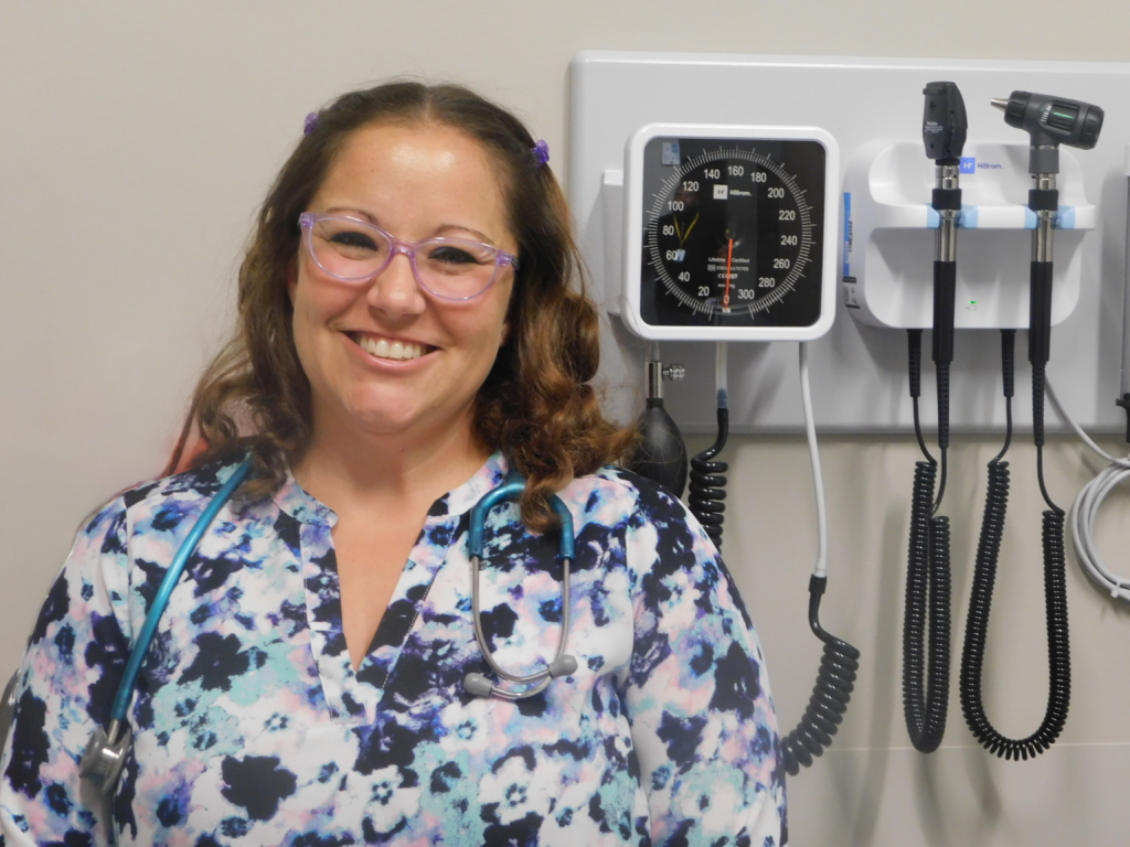 Asia McCoy, nurse practitioner, smiles in an exam room